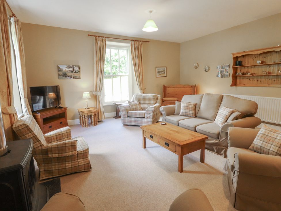 A living room with a sofa and armchairs at Hawkshead Hall in Hawkshead