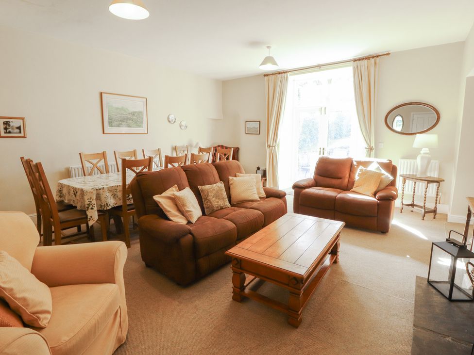 A living room with a sofa and dining table at Hawkshead Hall in Hawkshead