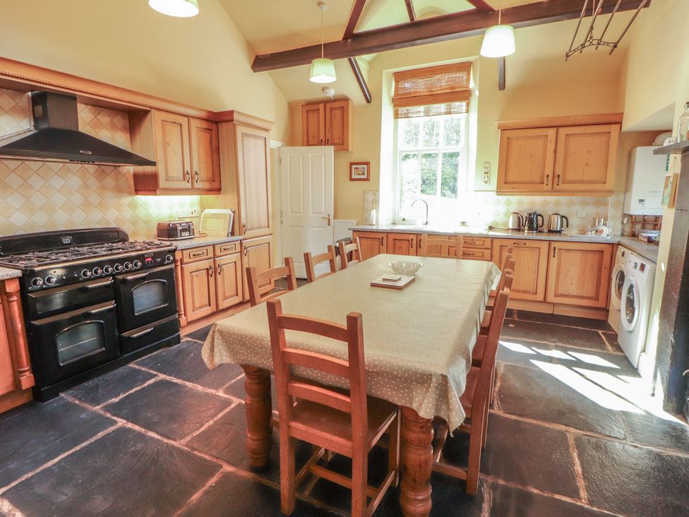 A kitchen with a dining table and appliances at Hawkshead Hall in Hawkshead