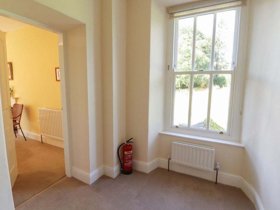 A hallway with a window and a fire extinguisher at Hawkshead Hall in Hawkshead