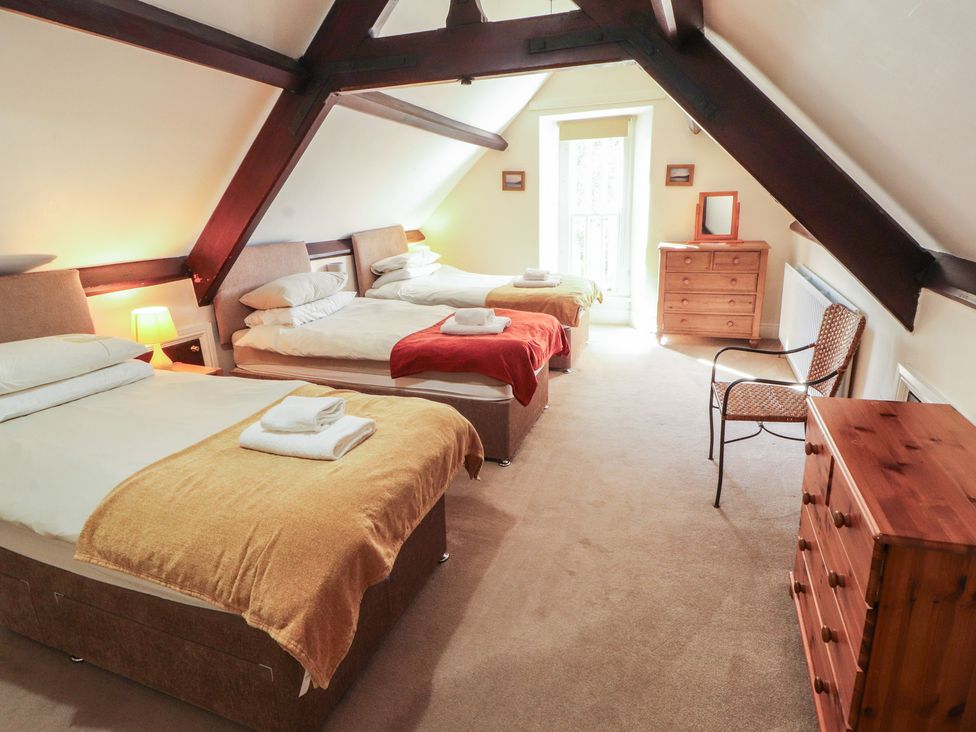 A bedroom with three beds and a dresser at Hawkshead Hall in Hawkshead