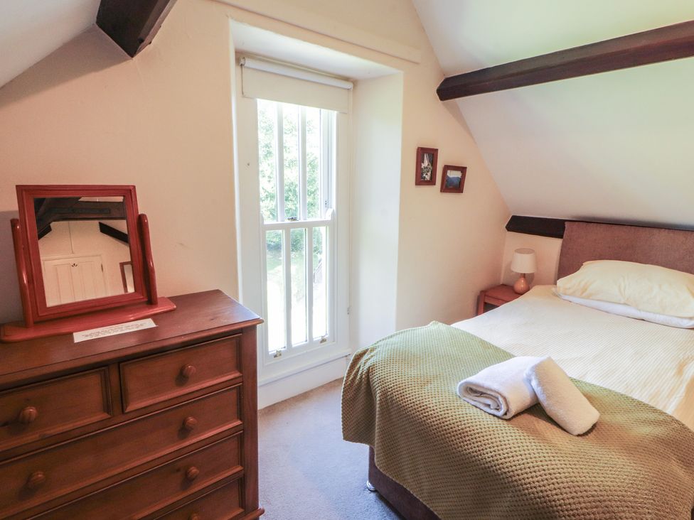 A bedroom with a bed and a mirror at Hawkshead Hall in Hawkshead