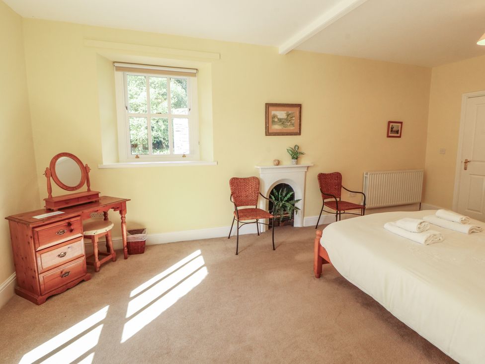A bedroom with a bed and dresser at Hawkshead Hall in Hawkshead