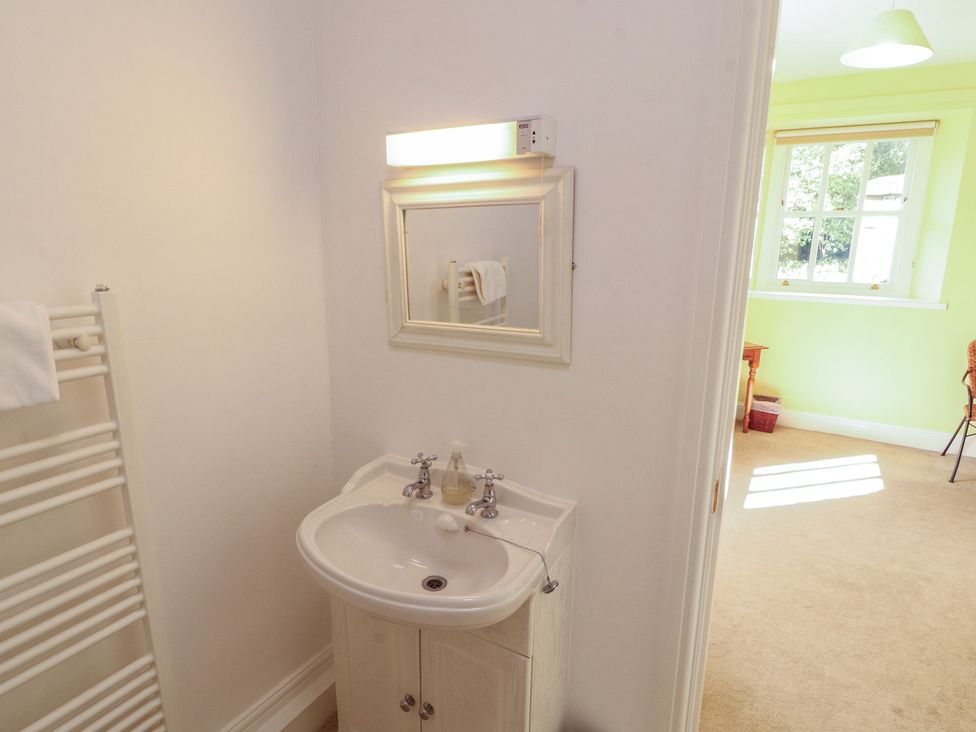 A bathroom with a sink and mirror at Hawkshead Hall in Hawkshead