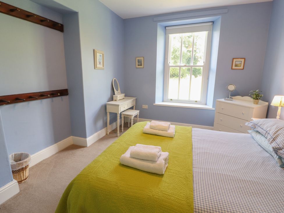A bedroom with a bed and desk at Hawkshead Hall in Hawkshead