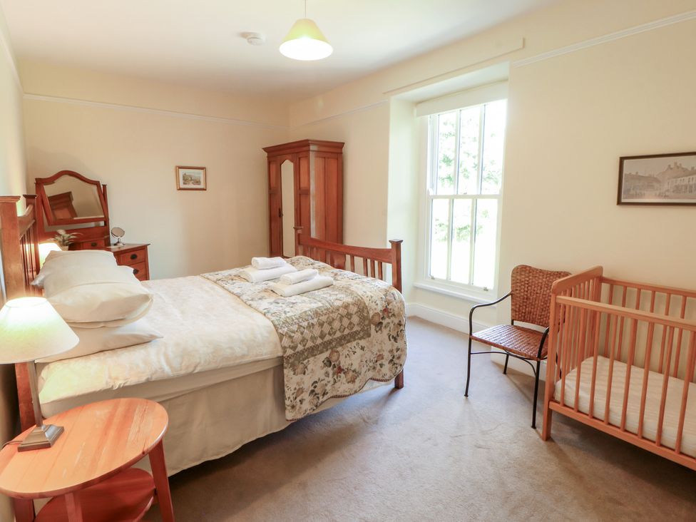 A bedroom with a bed and crib at Hawkshead Hall in Hawkshead