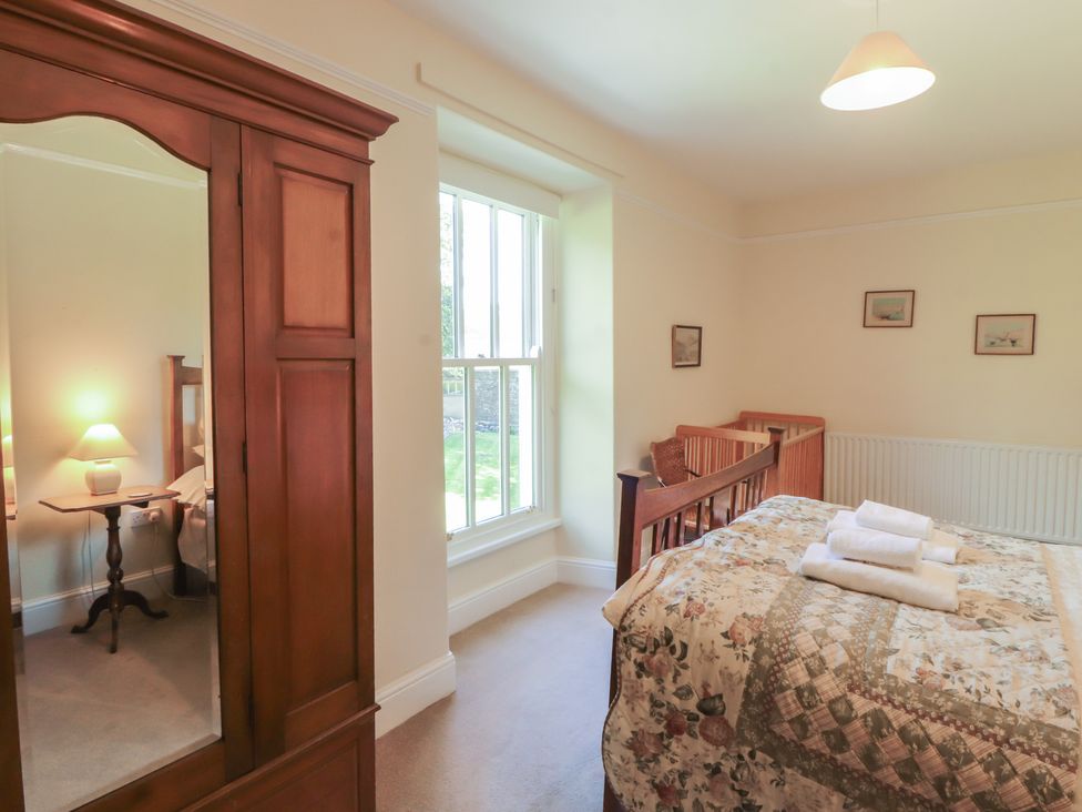 A bedroom with a bed and wardrobe at Hawkshead Hall in Hawkshead