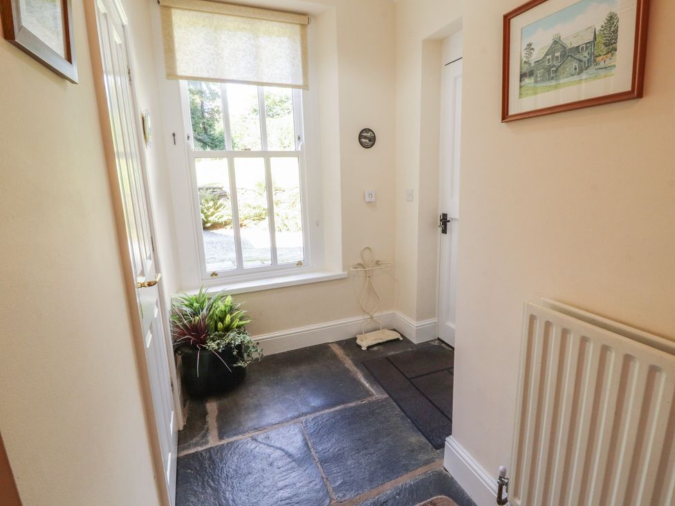 A hallway with a window and a plant at Hawkshead Hall in Hawkshead