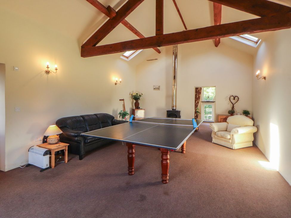 A recreation room with a ping pong table and sofas at Hawkshead Hall in Hawkshead