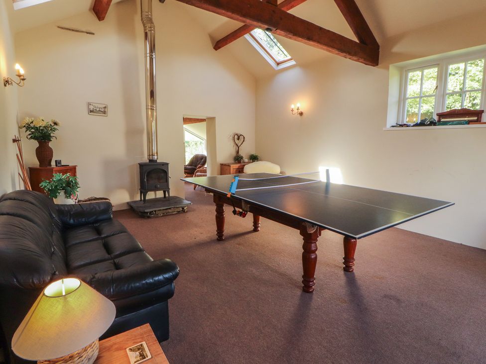 A recreation room with a ping pong table and sofa at Hawkshead Hall in Hawkshead
