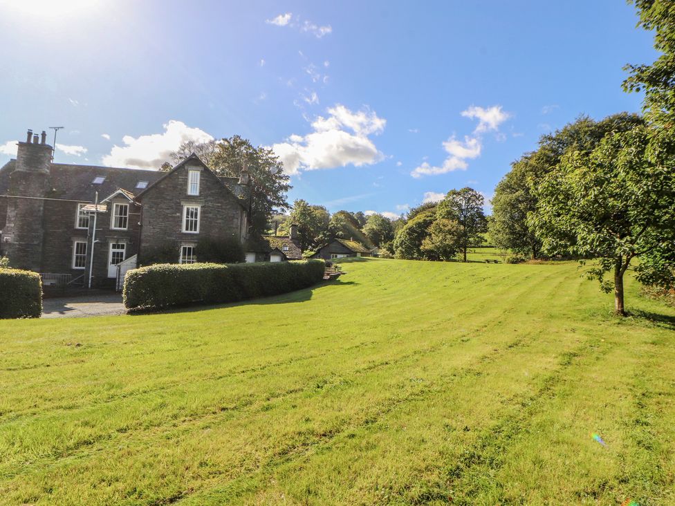 A house with a lawn and trees at Hawkshead Hall in Hawkshead