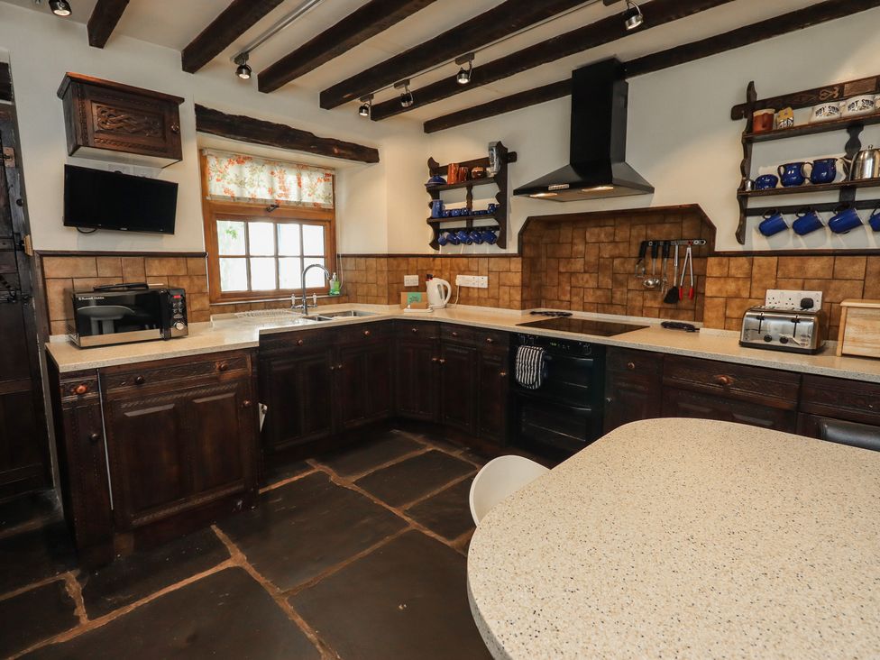 A kitchen with cabinets, sink, stove and appliances at Rose Cottage Coniston