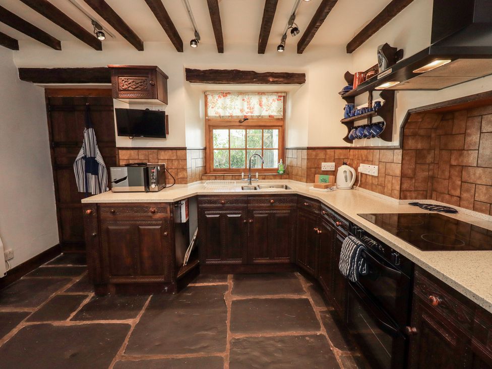 A kitchen with a sink and stove at Rose Cottage Coniston in coniston