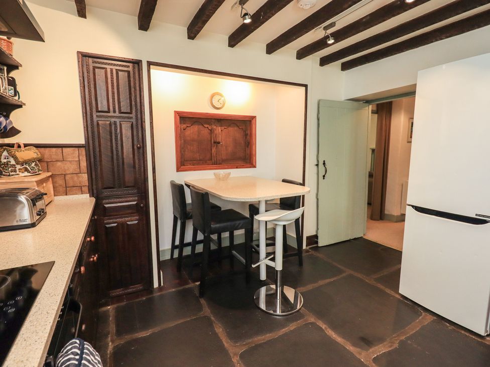 A kitchen with a table and stools at Rose Cottage Coniston in coniston
