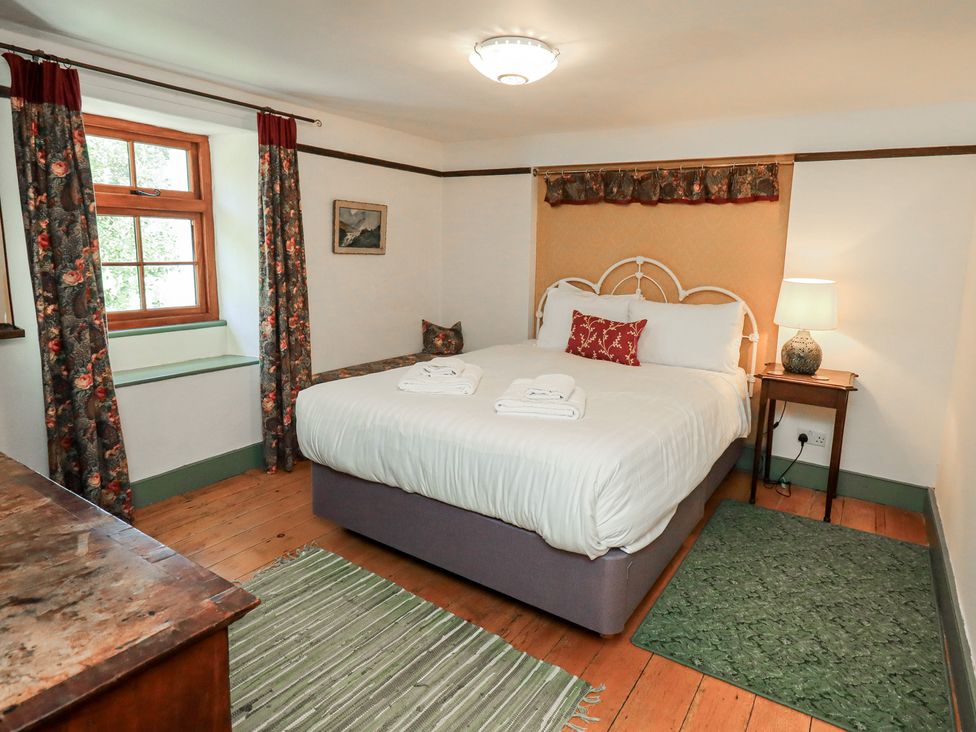 A bedroom with a bed and lamp at Rose Cottage Coniston in coniston