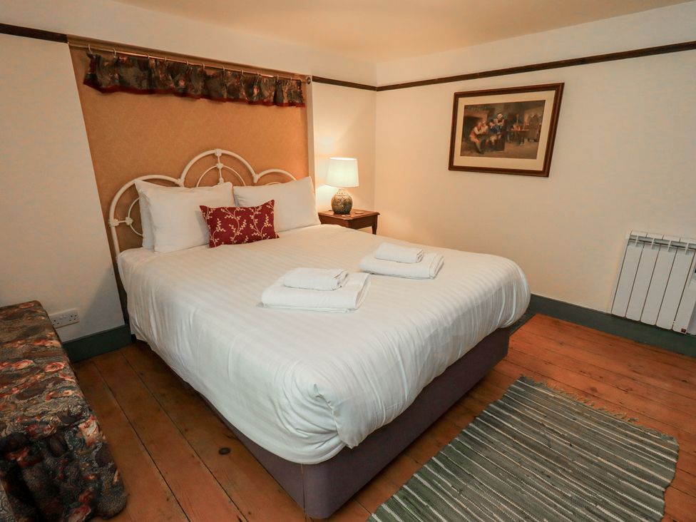A bedroom with a bed and bedside table at Rose Cottage Coniston