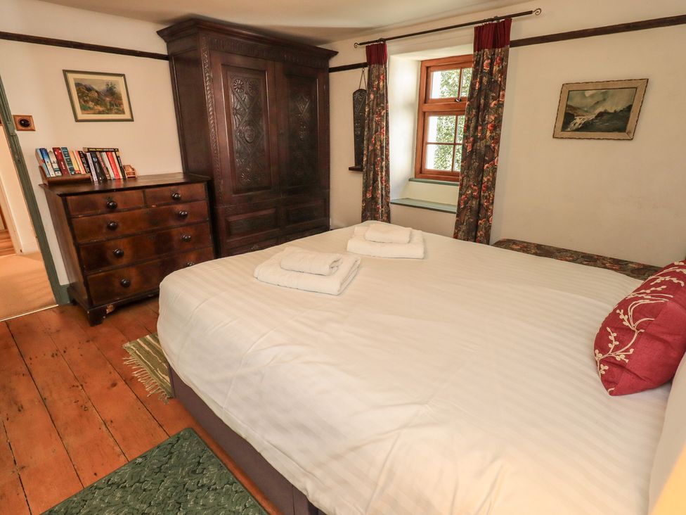 A bedroom with a bed and wardrobe at Rose Cottage Coniston