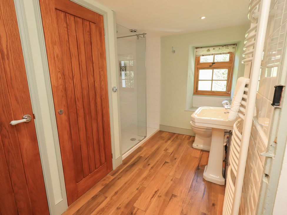 A bathroom with a shower, toilet, and sink at Rose Cottage Coniston