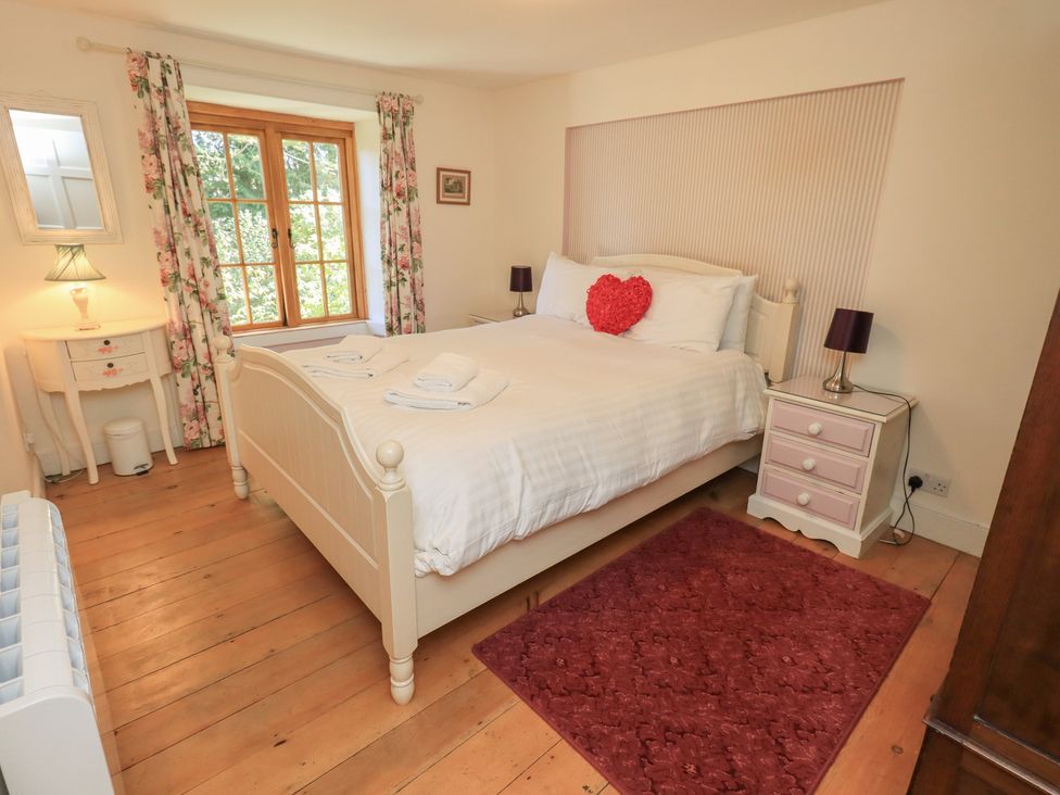 A bedroom with a bed and bedside table at Rose Cottage Coniston