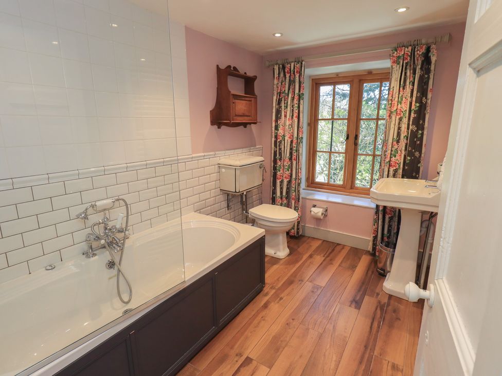 A bathroom with a bathtub, toilet, and sink at Rose Cottage Coniston