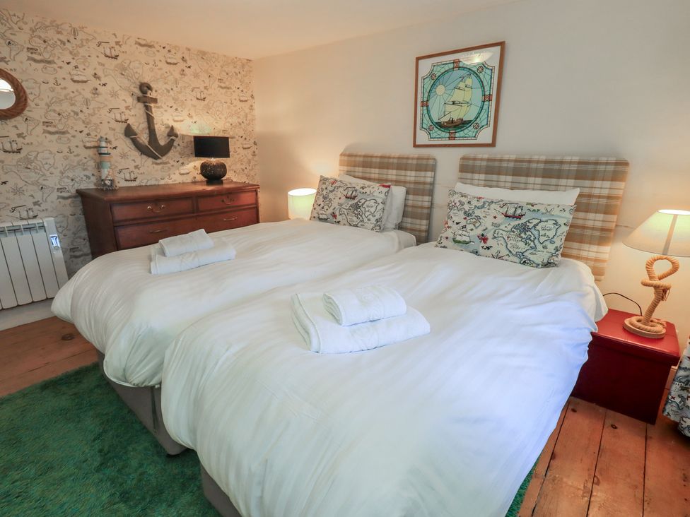 A bedroom with twin beds and wooden furniture at Rose Cottage Coniston in coniston