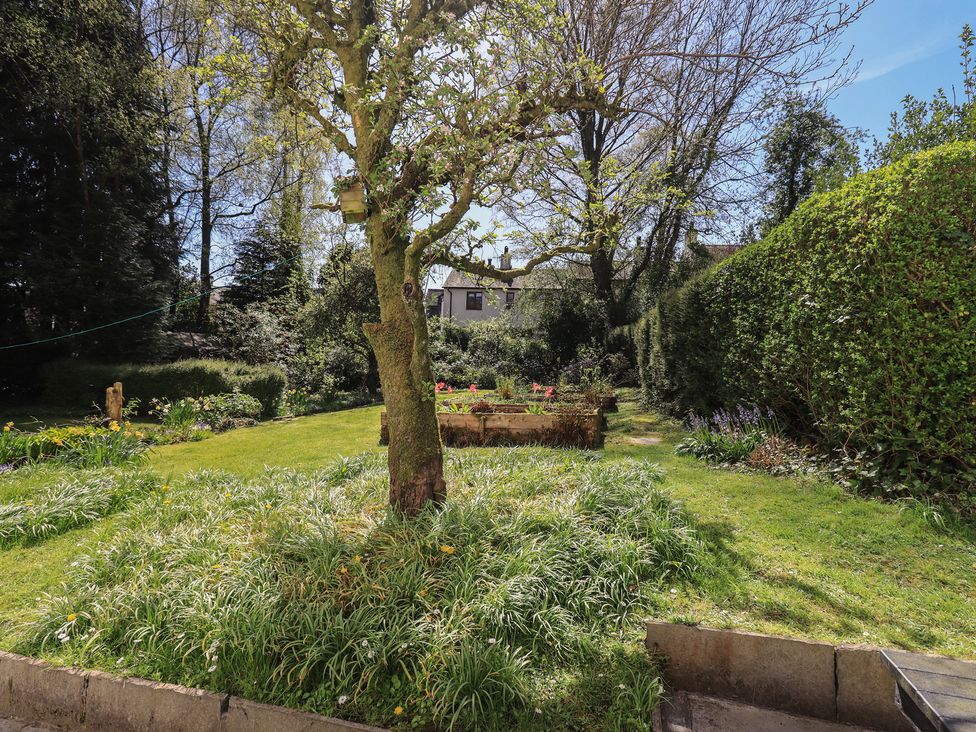 A garden with trees and flowers at Rose Cottage Coniston