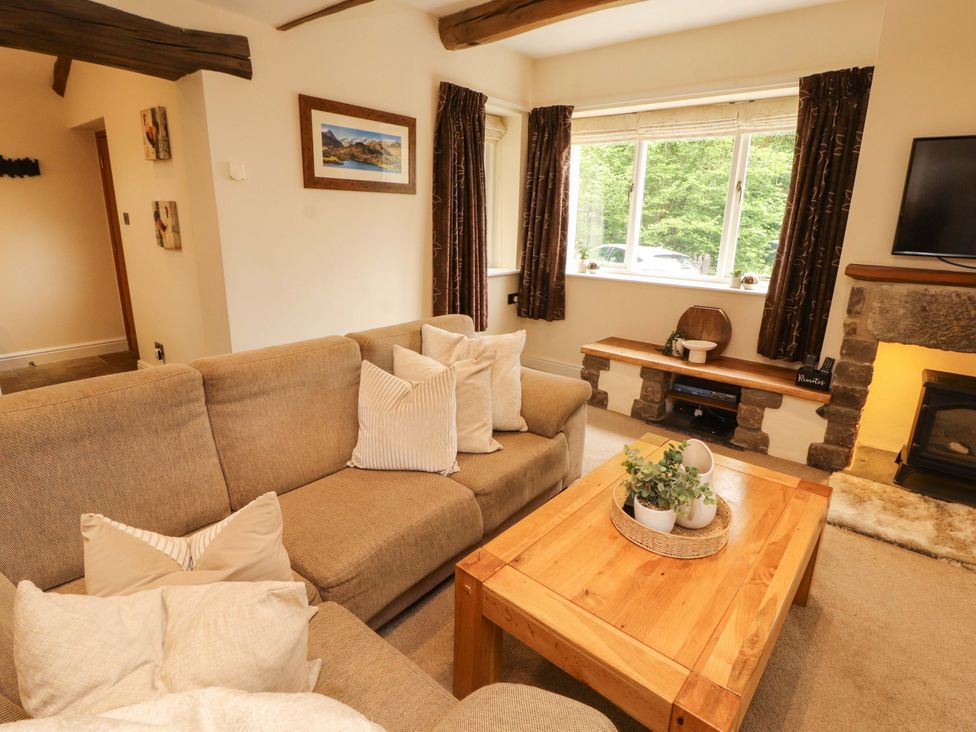 A living room with a sofa and coffee table at Durham Bridge Barn in Crosthwaite