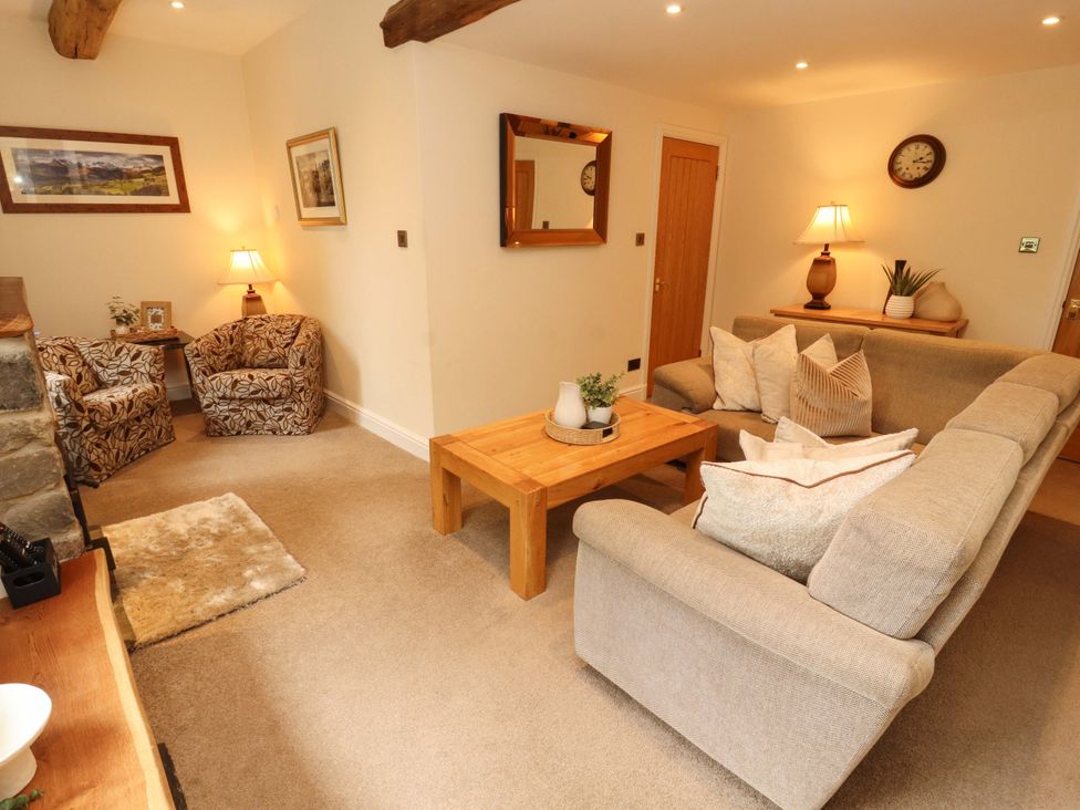 A living room with a sofa and armchairs at Durham Bridge Barn in Crosthwaite