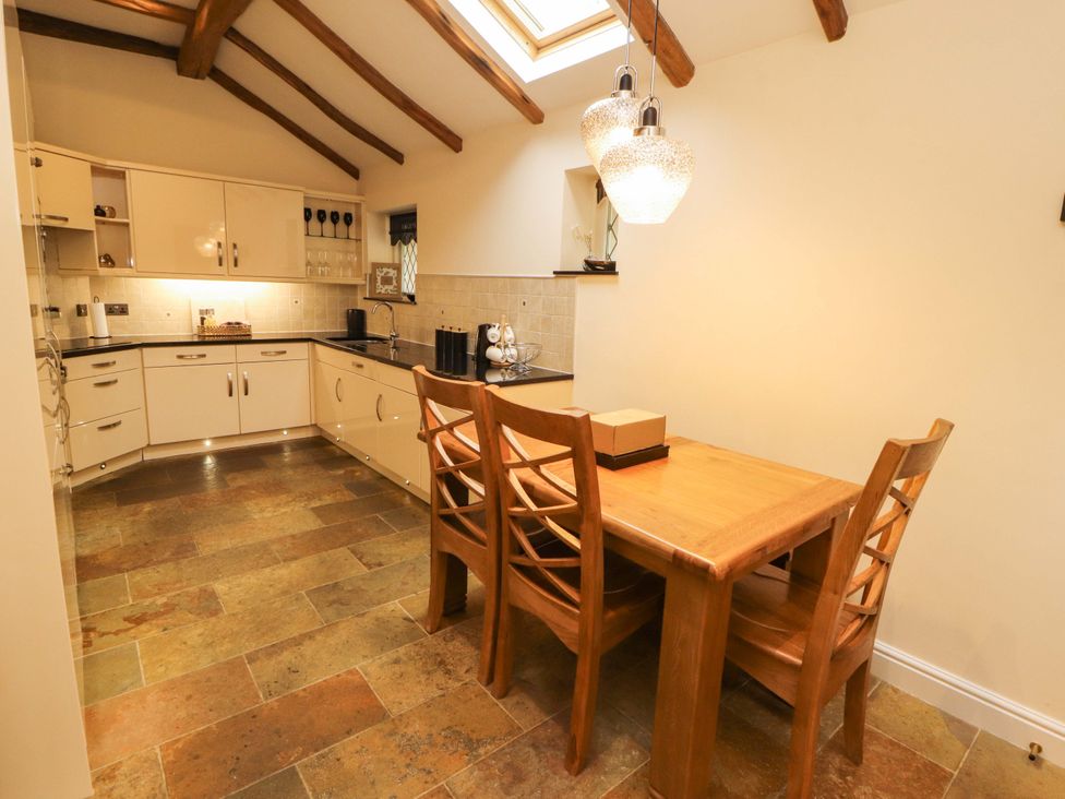 A kitchen with a dining table and chairs at Durham Bridge Barn in Crosthwaite