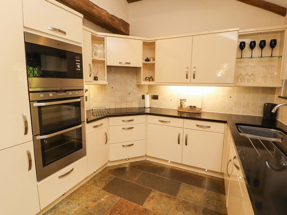 A kitchen with cabinets and appliances at Durham Bridge Barn in Crosthwaite