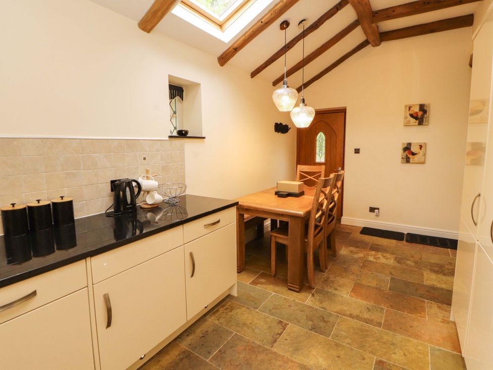 A kitchen with a dining table and chairs at Durham Bridge Barn in Crosthwaite