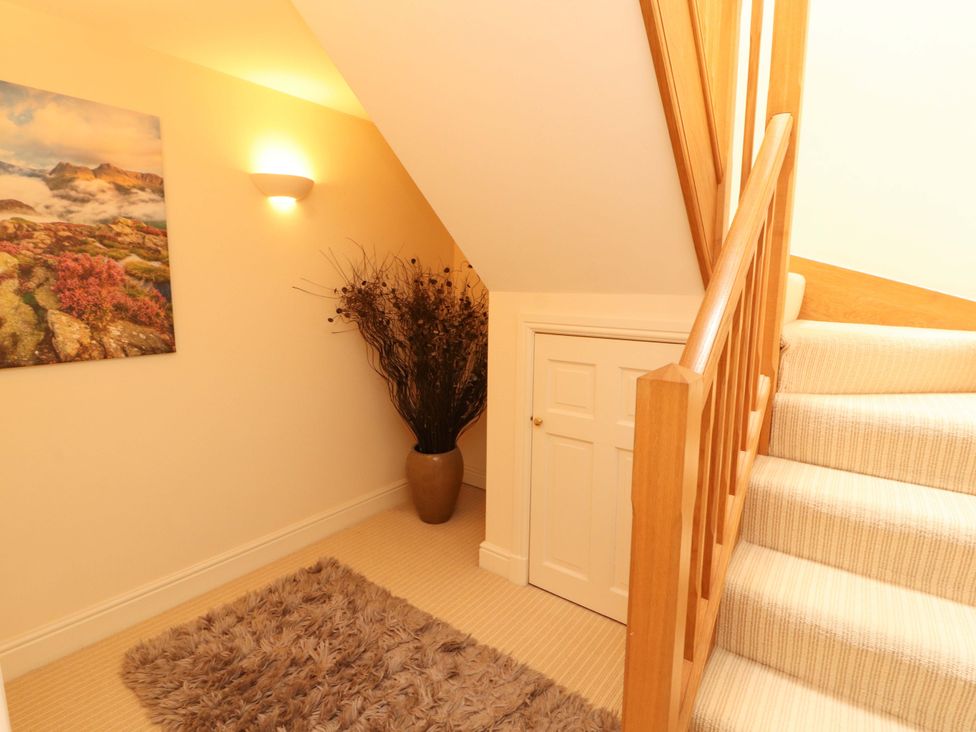 A hallway with stairs and a plant at Durham Bridge Barn in Crosthwaite