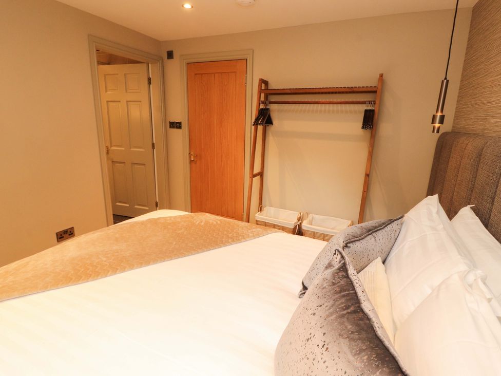 A bedroom with a bed and a coatrack at Durham Bridge Barn in Crosthwaite