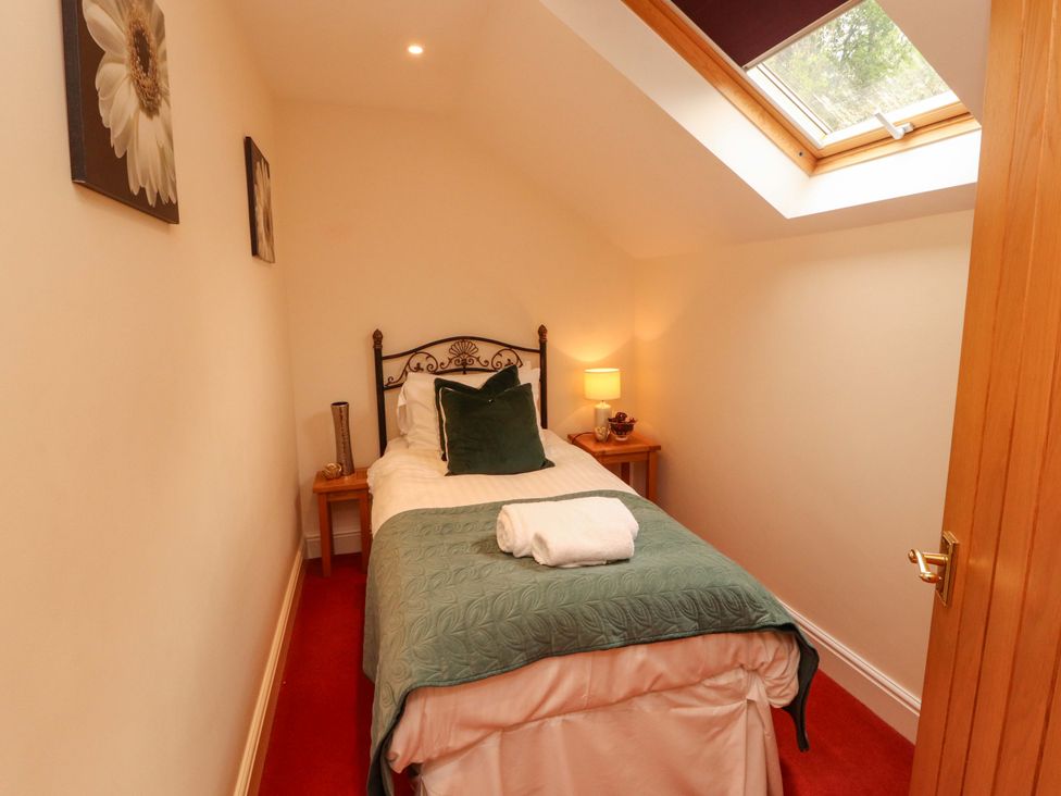 A bedroom with a single bed and bedside table at Durham Bridge Barn in Crosthwaite