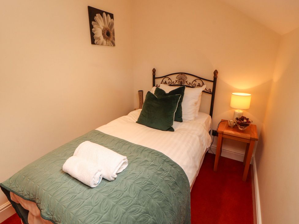 A bedroom with a single bed and side table at Durham Bridge Barn in Crosthwaite