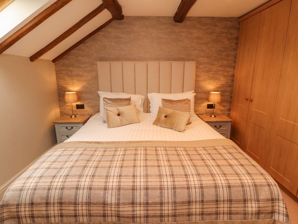 A bedroom with a bed and bedside tables at Durham Bridge Barn in Crosthwaite