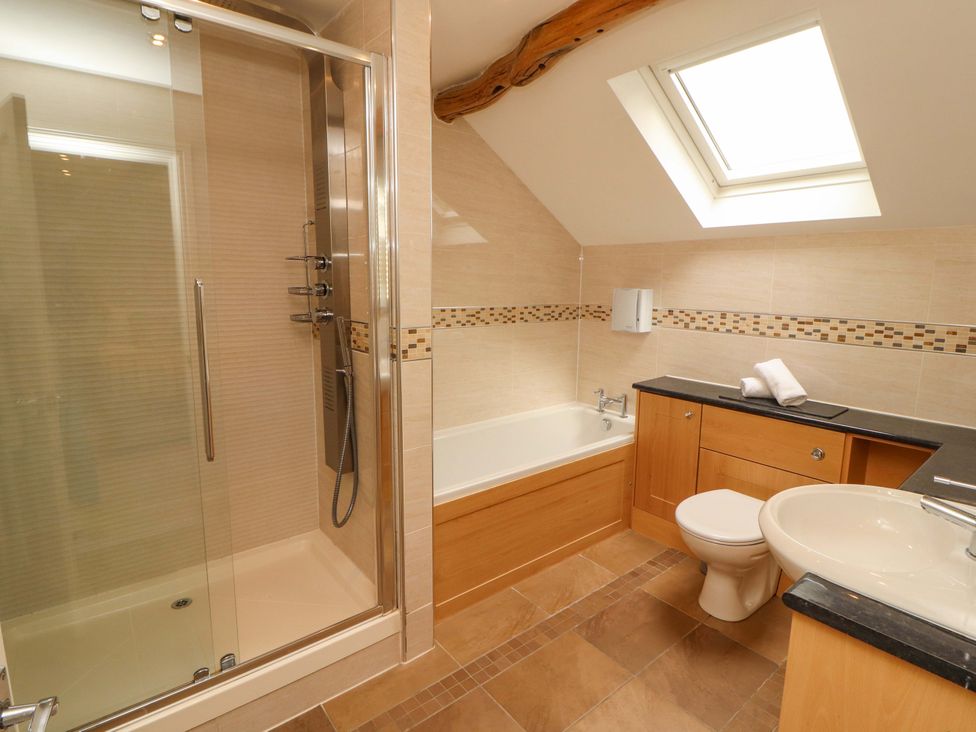 A bathroom with a shower and bathtub at Durham Bridge Barn in Crosthwaite