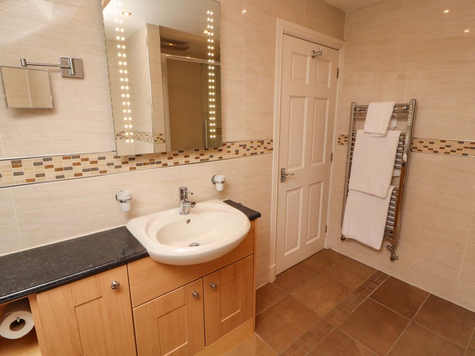 A bathroom with a washbasin and towel rack at Durham Bridge Barn in Crosthwaite