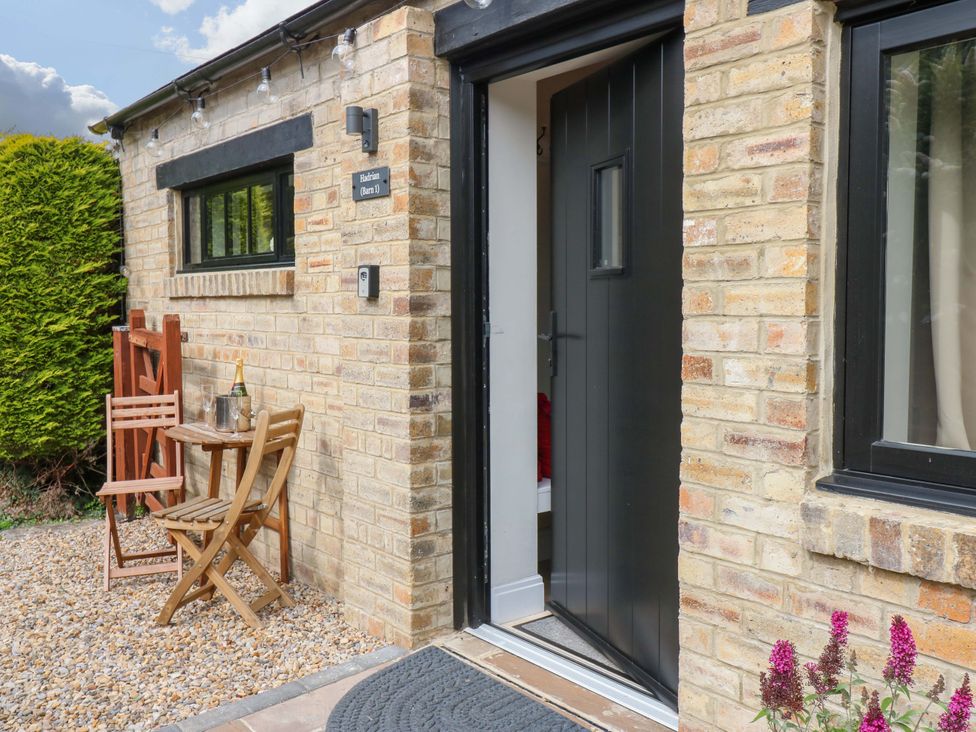 An outdoor entryway with a door, table, chairs, and plants at Hadrian Barn 1 Ebchester