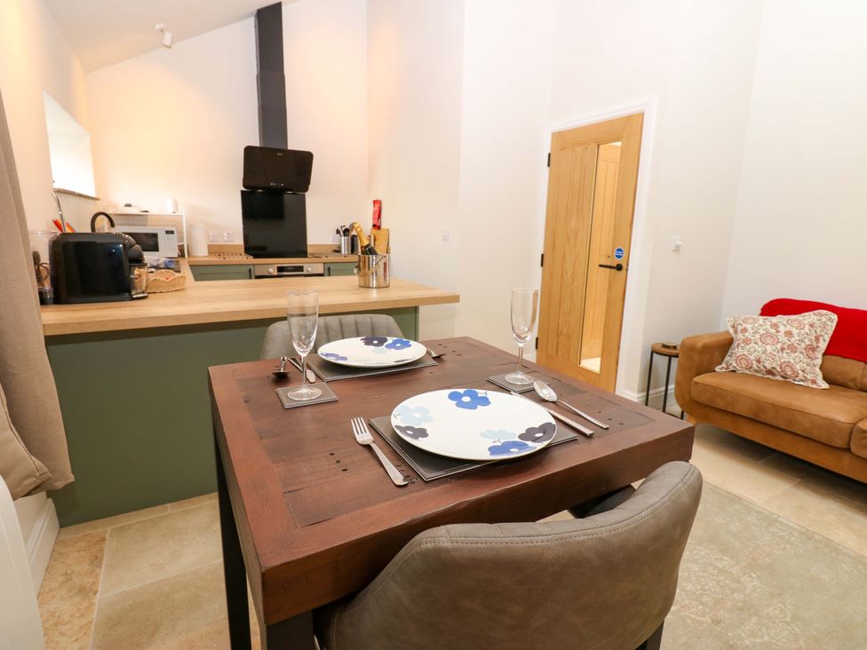 A dining area with a table set and a sofa at Hadrian Barn 1 Ebchester