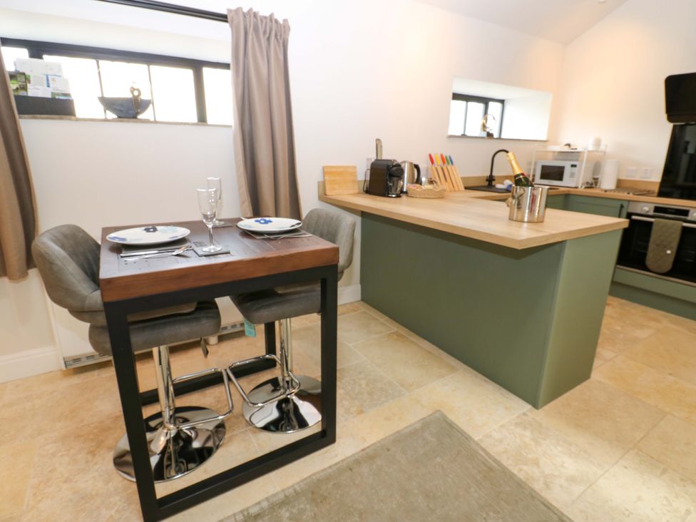 A kitchen with a dining table and chairs at Hadrian Barn 1 in Ebchester