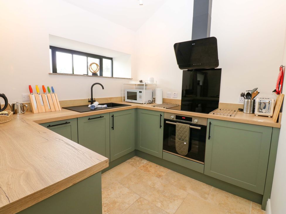 A kitchen with a sink, microwave, and oven at Hadrian Barn 1 Ebchester