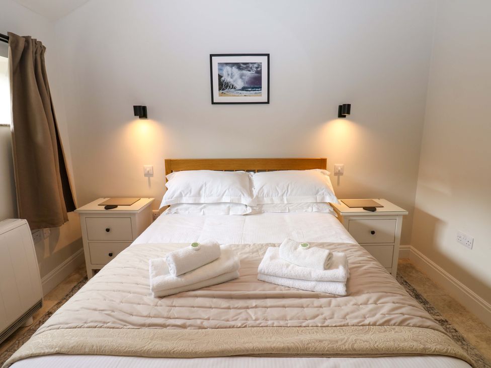 A bedroom with a bed and nightstands at Hadrian Barn 1 in Ebchester