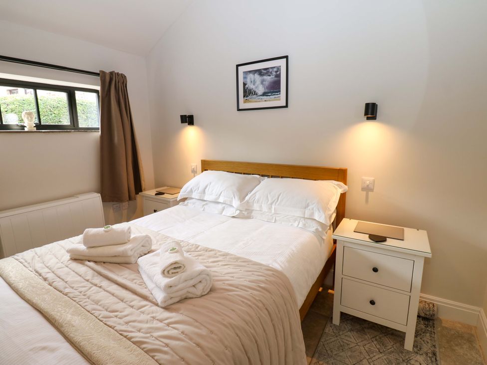 A bedroom with a bed and side table at Hadrian Barn 1 Ebchester