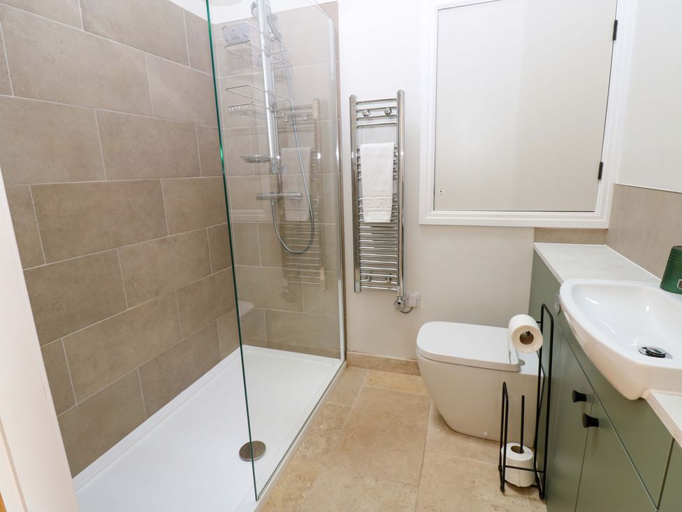 A bathroom with shower, toilet, and sink at Hadrian Barn 1, Ebchester