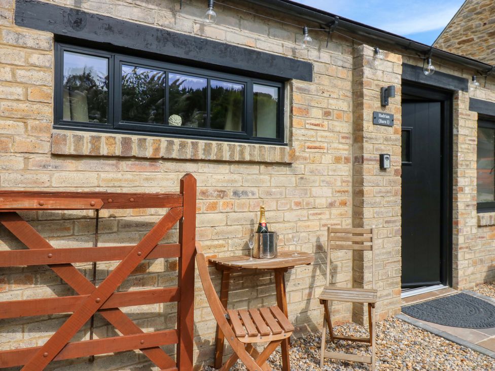 An outdoor area with a gate, table, and chairs at Hadrian Barn 1 in Ebchester