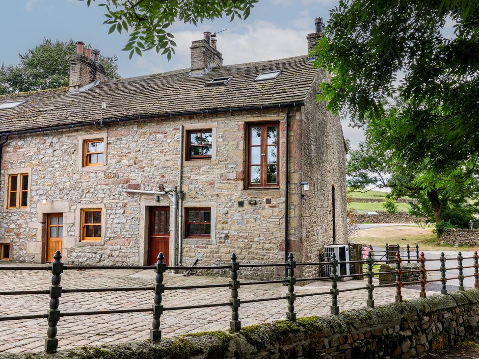 A stone building with windows and a door at Bay Horse Cottage in Skipton