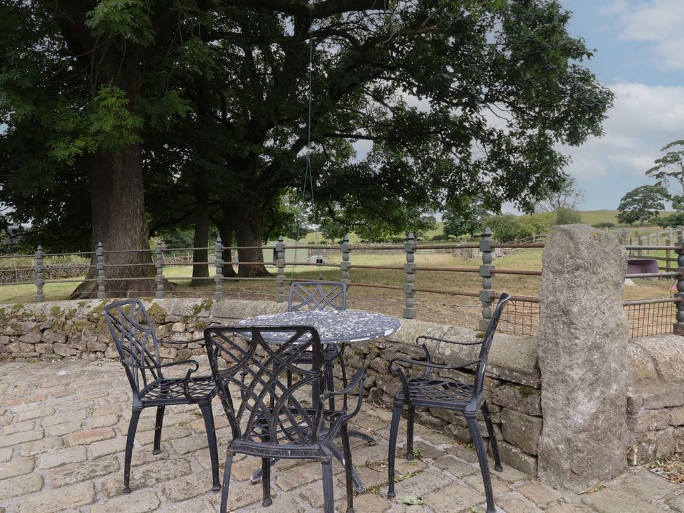 An outdoor seating area with a table and chairs at Bay Horse Cottage in Skipton