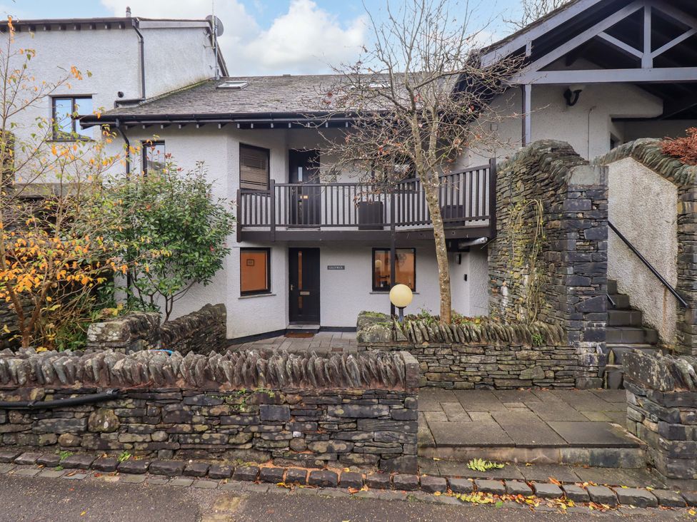 A building with a balcony and stone wall at Gillybeck in Ambleside