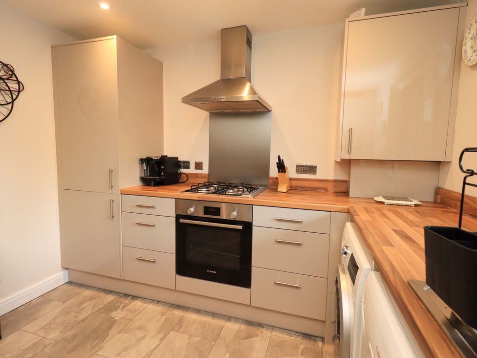 A kitchen with cabinets, gas stove, and coffee maker at Gillybeck in Ambleside